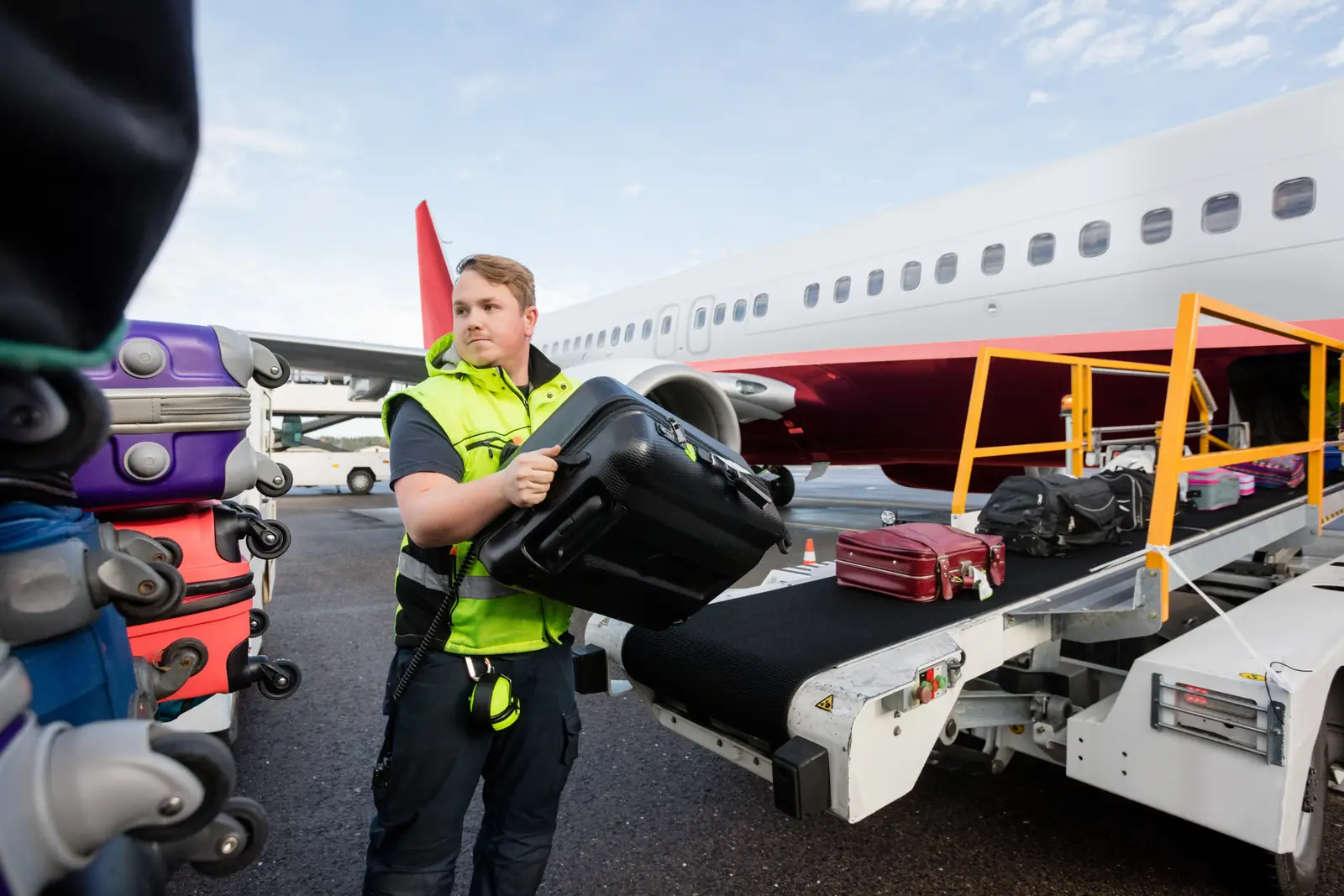 A ground handler loading baggage onto an aircraft